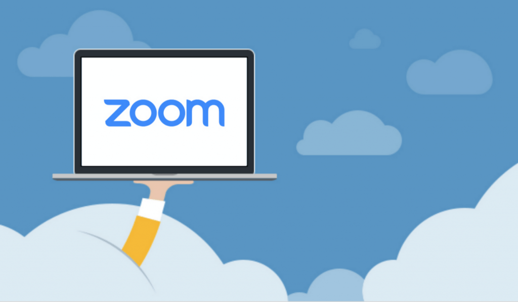 Zoom logo shown on laptop, which a person holds.
