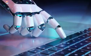 Image of robot fingers typing on computer
